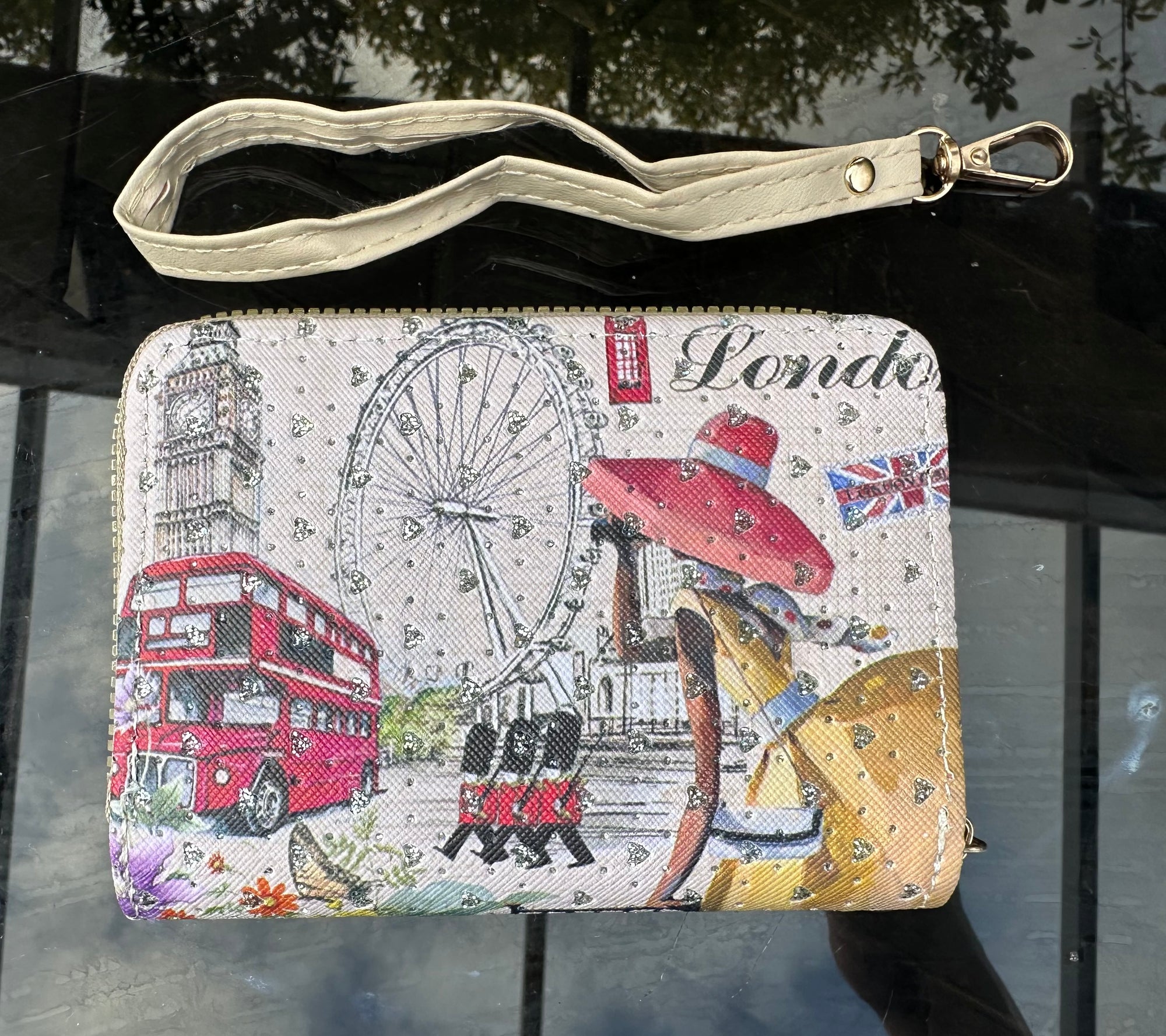 Wristlet with London-themed design featuring a double-decker bus, london eye, and British flag.